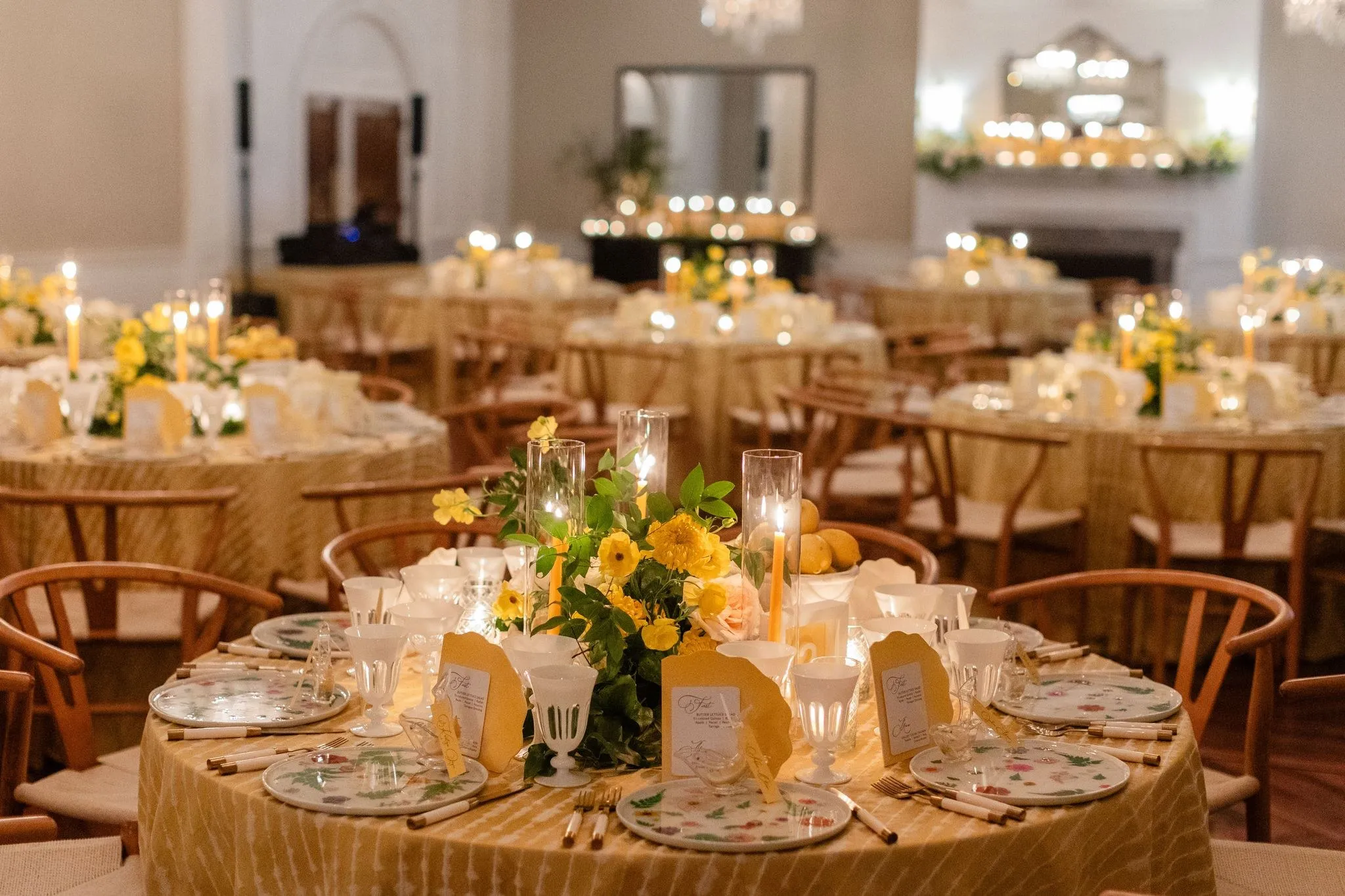 Event tables set with gold chairs and white florals.