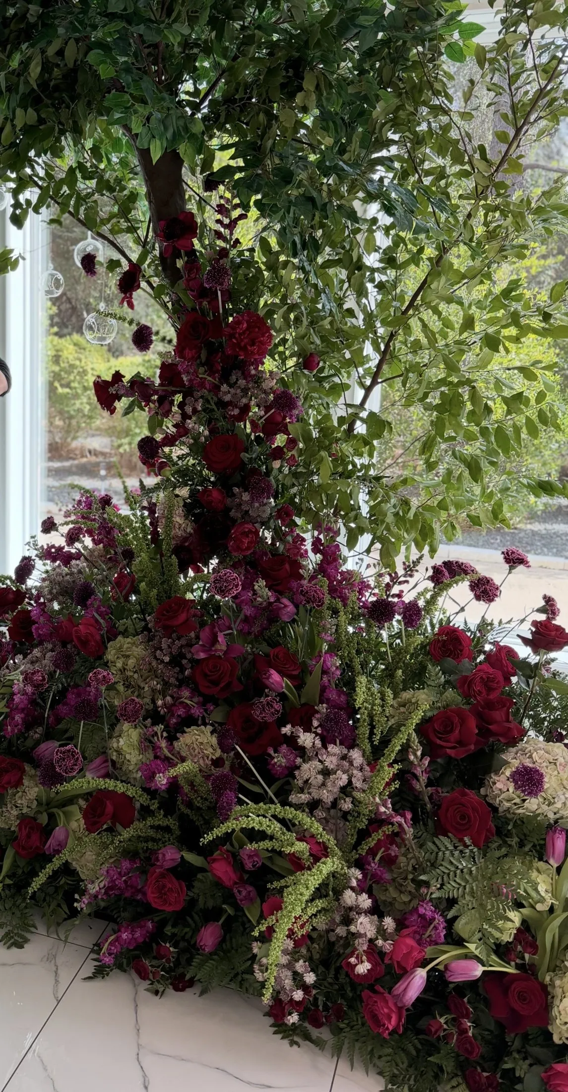 Burgundy and green floral installation climbing a staircase rail.