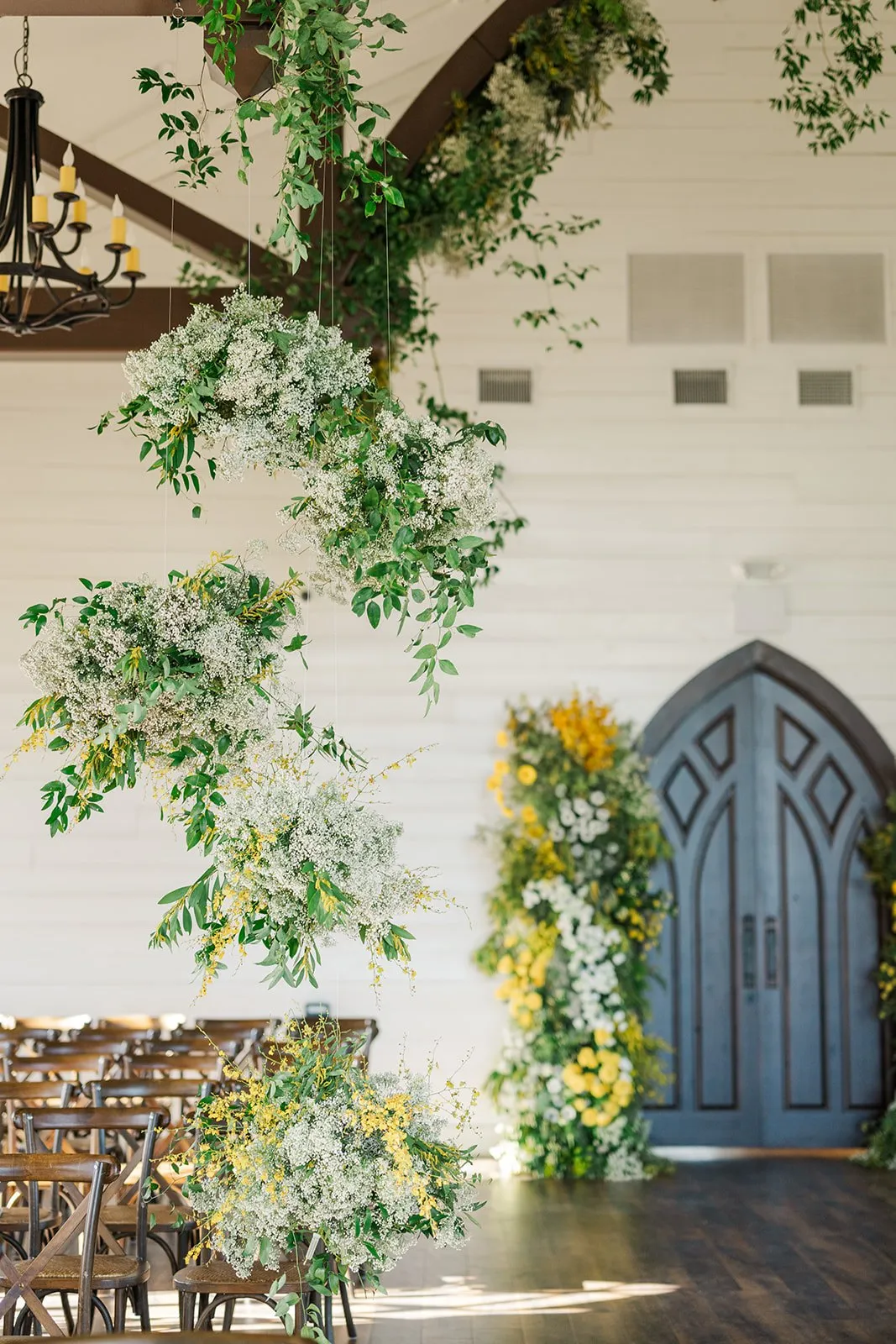 Yellow and white spring installation arching over chapel doors.