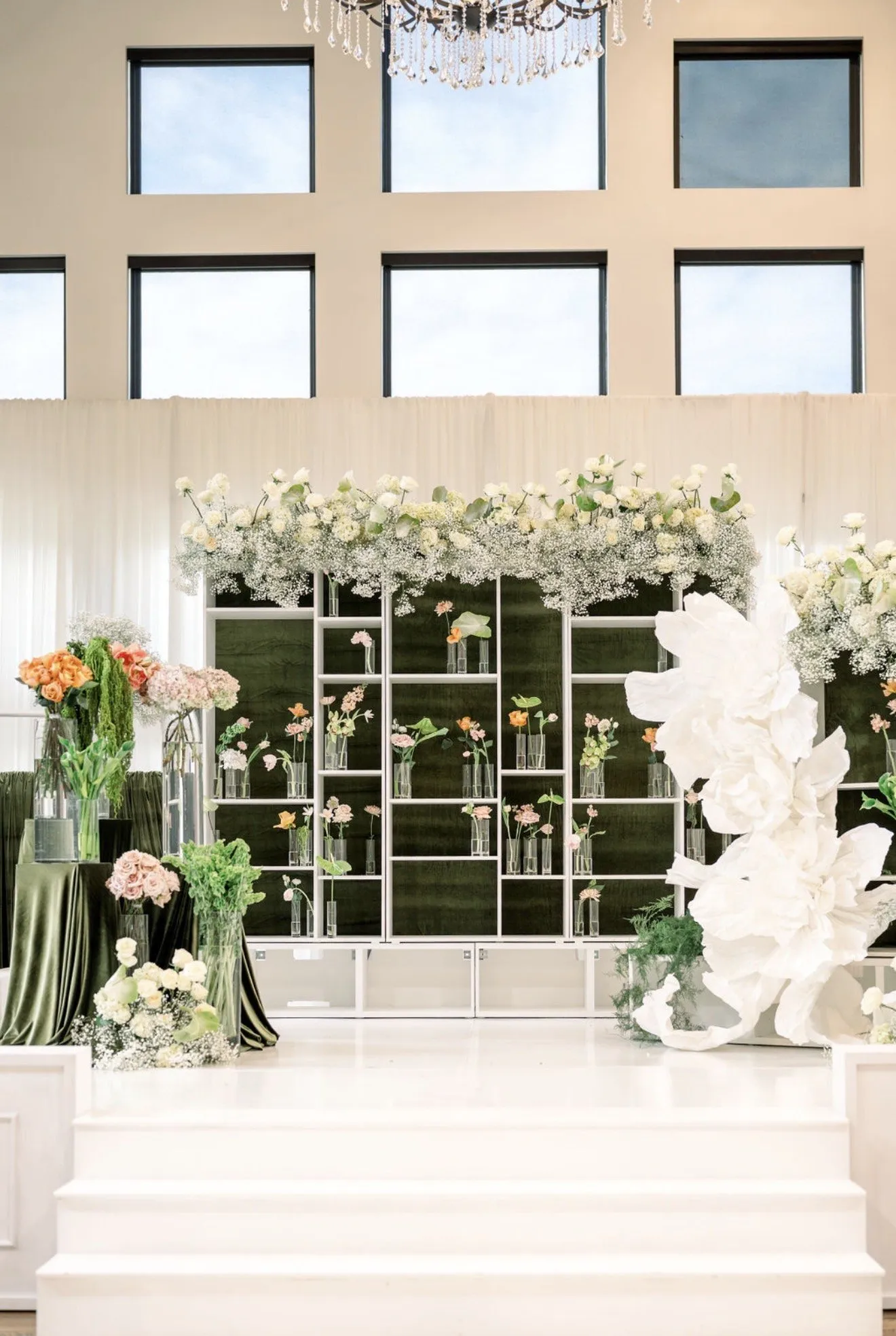 Mirror-panel altar wall crowned with white florals and calla lilies.