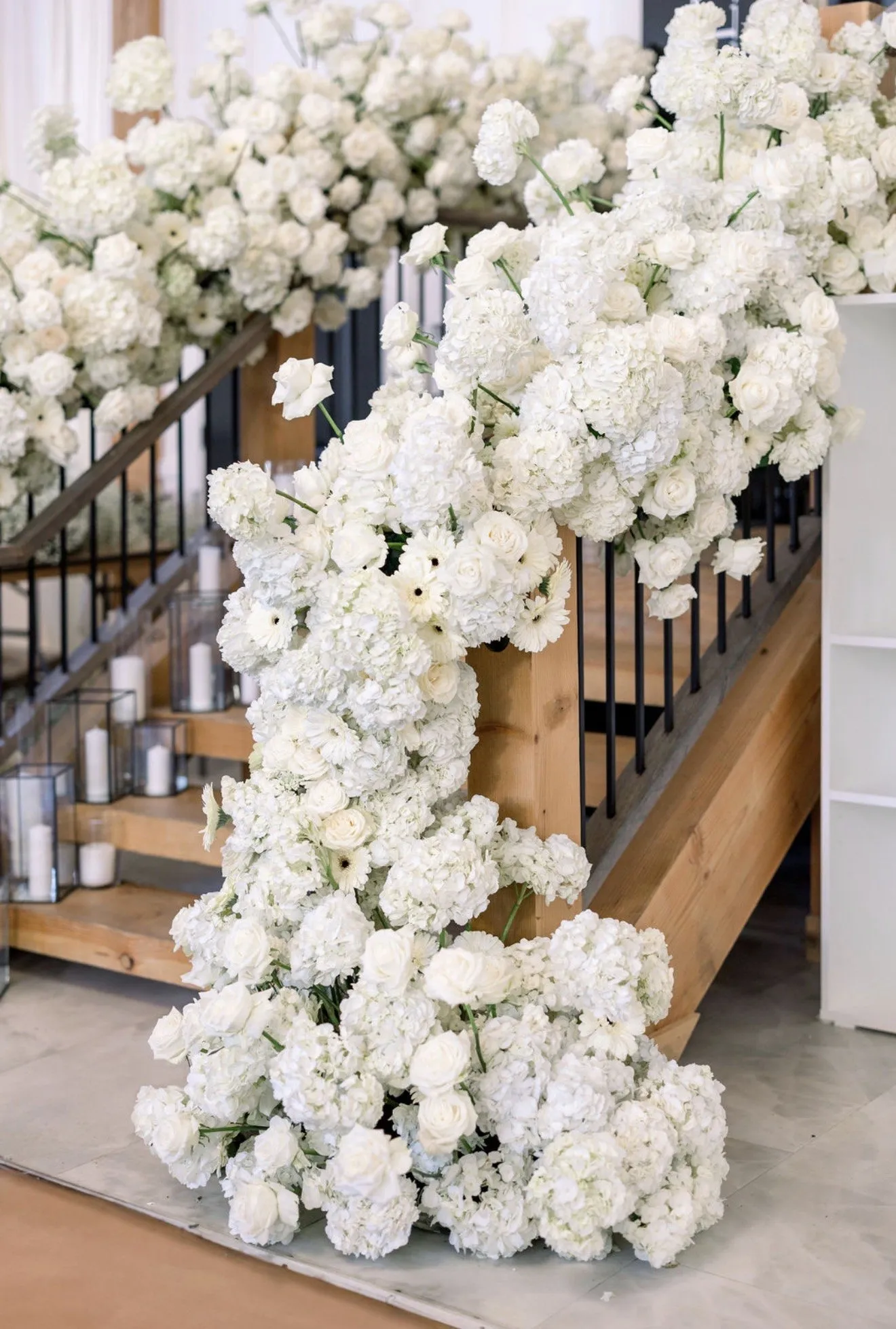 White hydrangea and rose installation cascading down a wooden staircase.