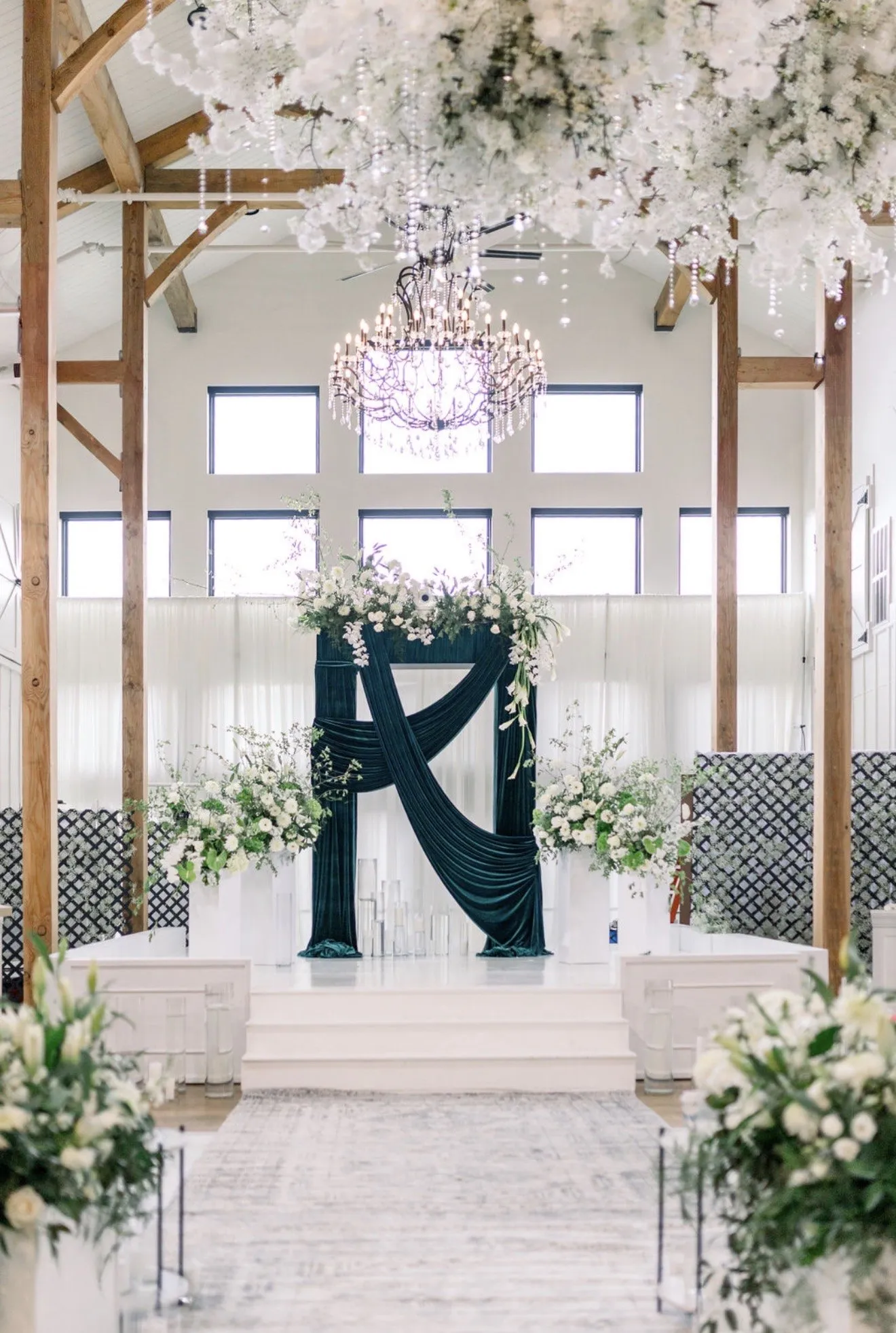 Altar draped in deep green velvet beneath a floral chandelier.