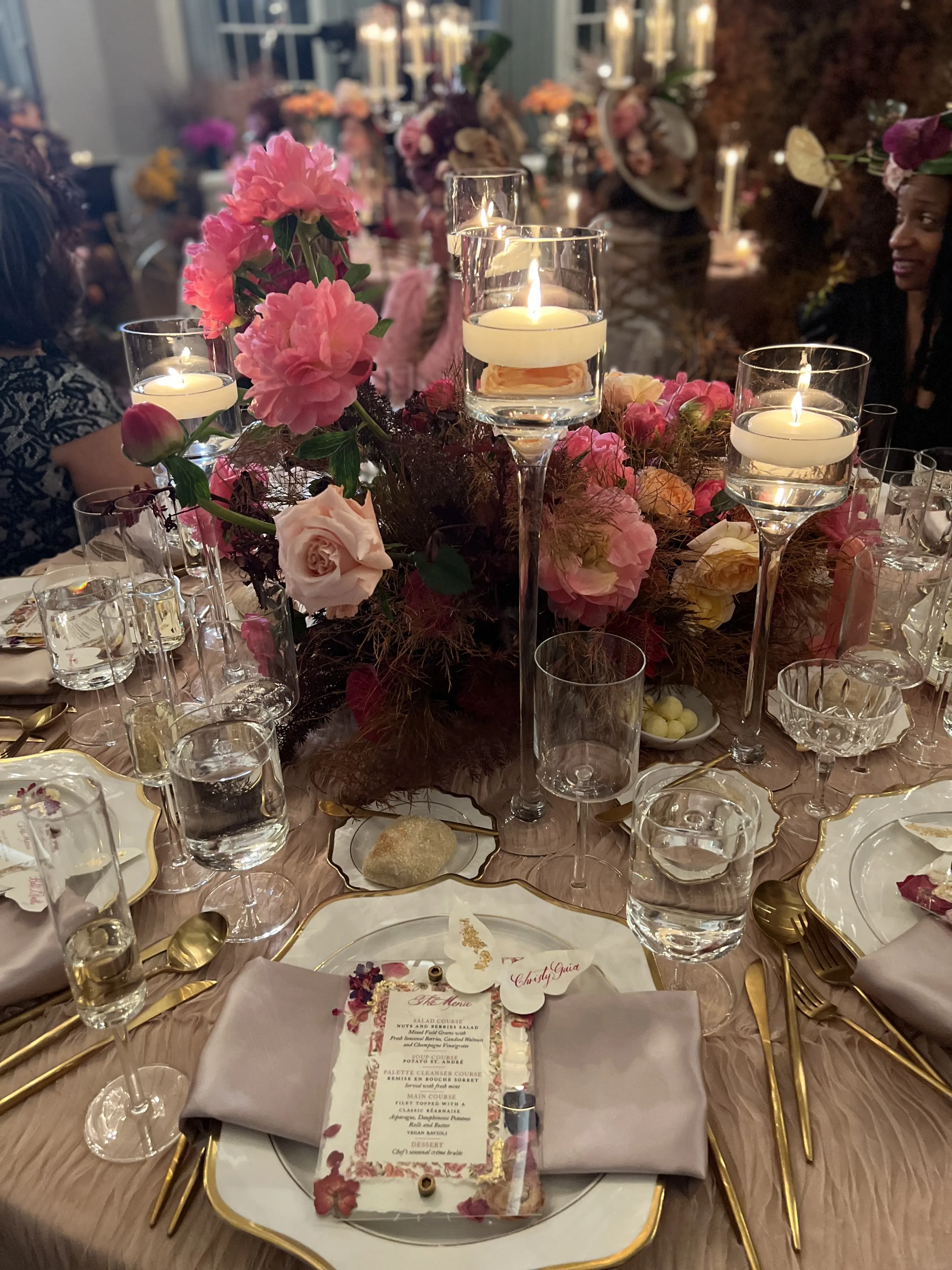 White chapel with timber trusses, hanging white floral clouds and a crystal chandelier over the ceremony stage.